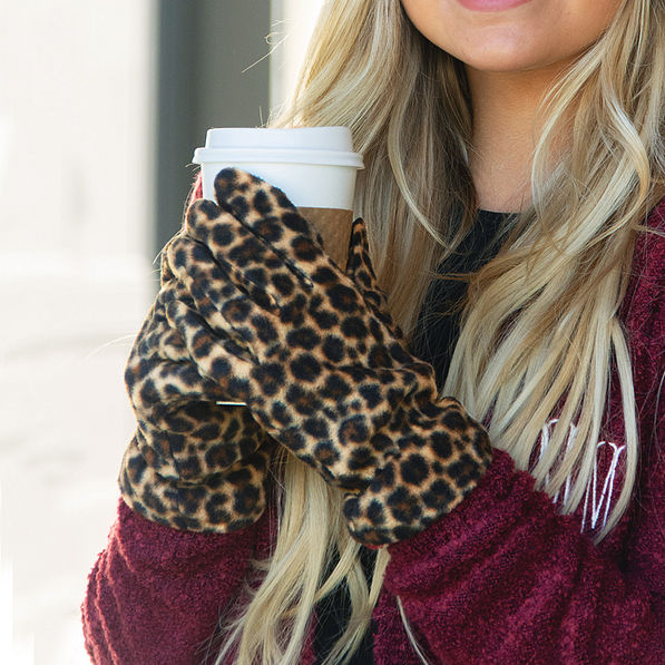 girl wearing leopard gloves holding coffee